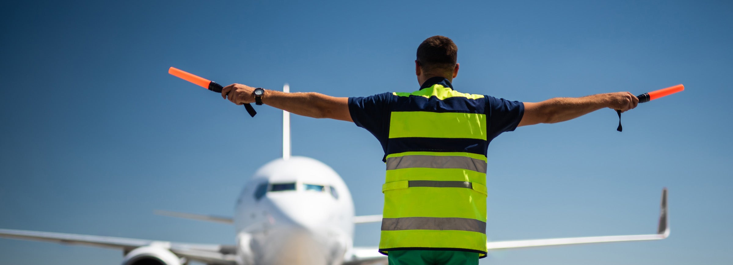 Airport Worker Directing Plane With Batons Image