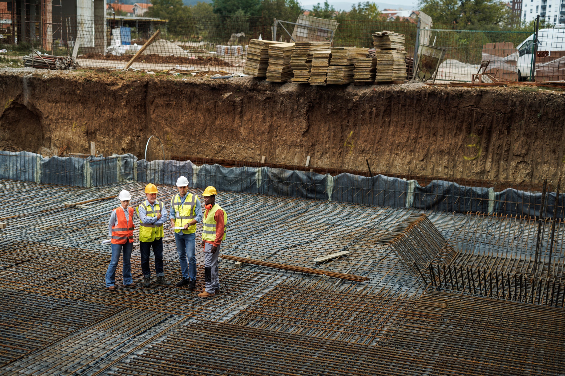 Group of Workers Standing in Construction Site Wearing High Visibility Clothing and Safety Gear Image